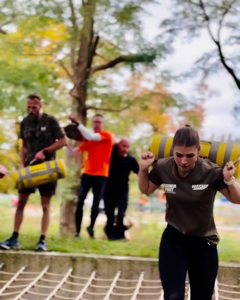 Deelnemers aan Bootcamp Outside die samen met zandzakken trainen in de buitenlucht